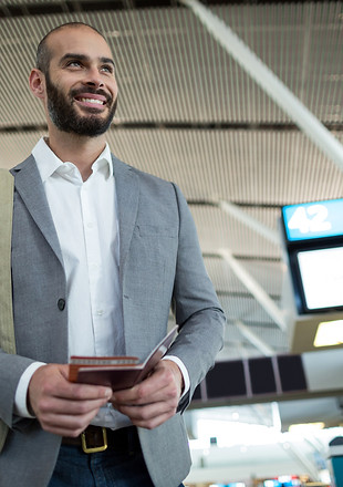 smiling-businessman-holding-boarding-pas