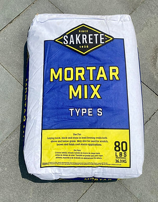 Bag of Sakrete Type S Mortar Mix, an 80-pound cement product, placed on a paved surface, commonly used for laying pavers, bricks, and stone masonry projects.