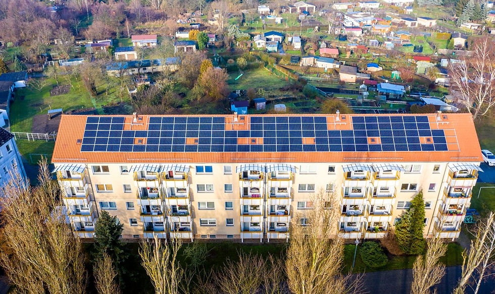 Luftaufnahme eines Mehrfamilienhauses mit Solaranlage auf dem Dach