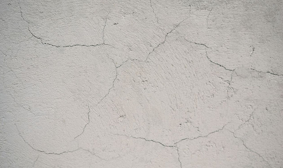 Risse in einer Betonwand als typische Schwachstelle fuer eindringende Feuchtigkeit im Keller