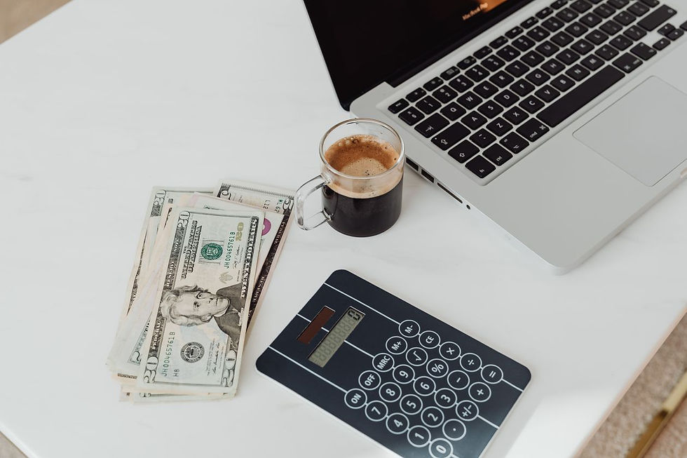 Schreibtisch mit Laptop, Taschenrechner und Geldscheinen bei der Nebenkosten- und Mietberechnung