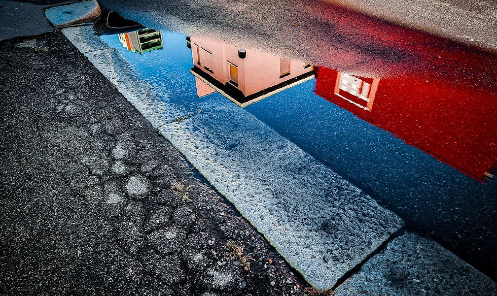 Gebäudespiegelung in einer Regenwasserpfütze