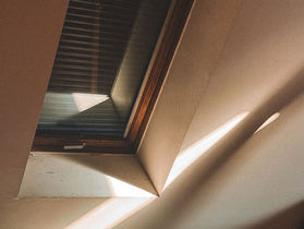 Ausgebauter Dachboden mit Dachschräge, Holzverkleidung und Dachfenster als Sinnbild für den Dachgeschossausbau in der Eigentümergemeinschaft