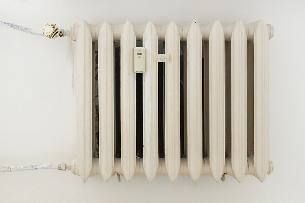 Weißer Heizkörper an der Wand einer renovierten Wohnung als Teil eines optimierten Heizsystems