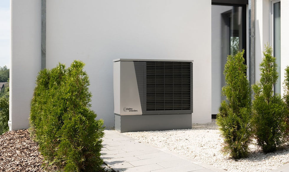 Aussengeraet einer Klimaanlage neben einer modernen Hausfassade mit Bepflanzung