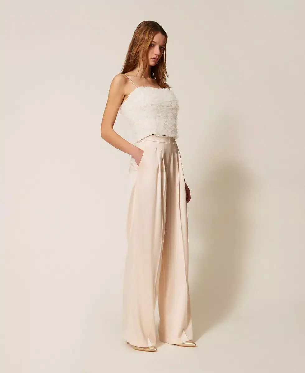 Pantalón palazzo beige de tejido fluido combinado con top blanco de tirantes de Twinset