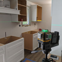 leveling upper cabinets, green laser level, kitchen installation