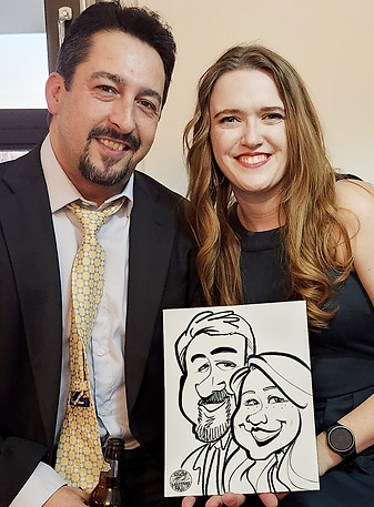 A couple holding up their quick one-minute aricature from Caricatures by Marietta at wedding or gala in Kansas City.