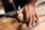 Furniture maker Crete carving wood with a chisel