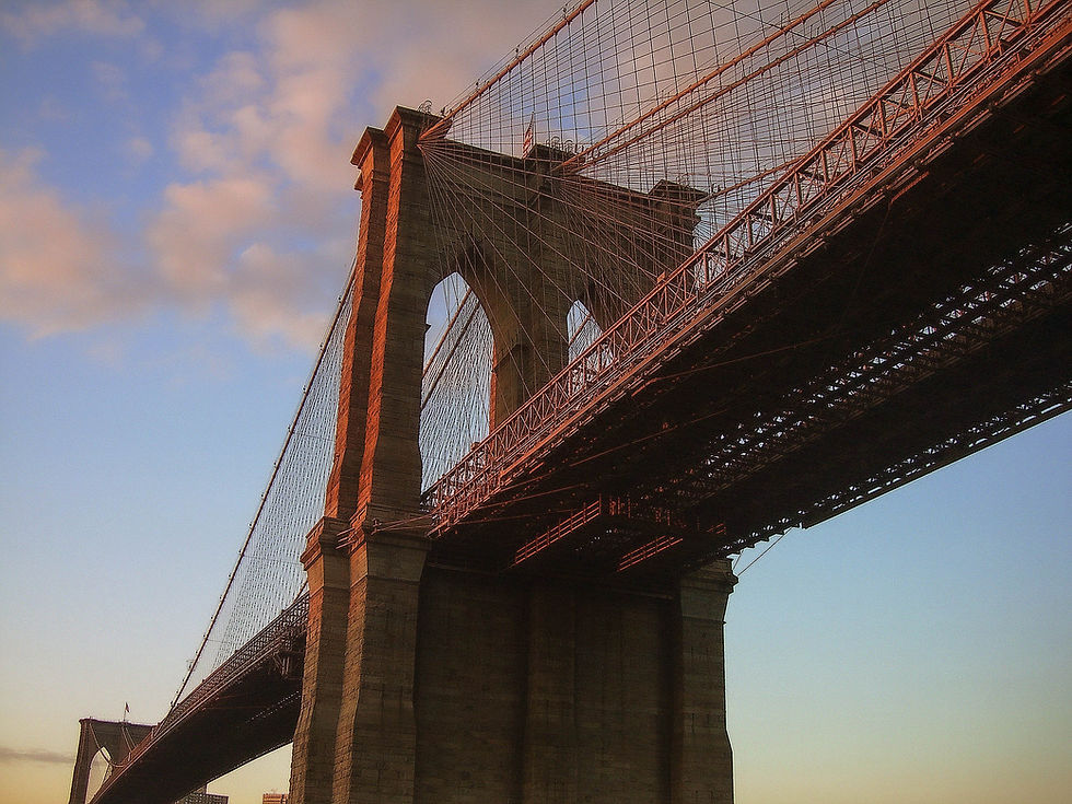 Brooklyn Bridge with red from the rising sun, New York, NY