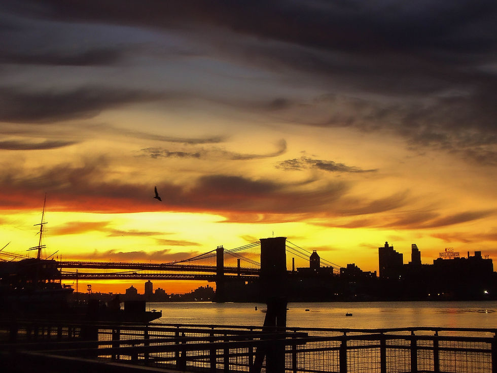 It's 6:05 am with a yellow orange sky over the Manhattan & Brooklyn Bridges, New York, NY