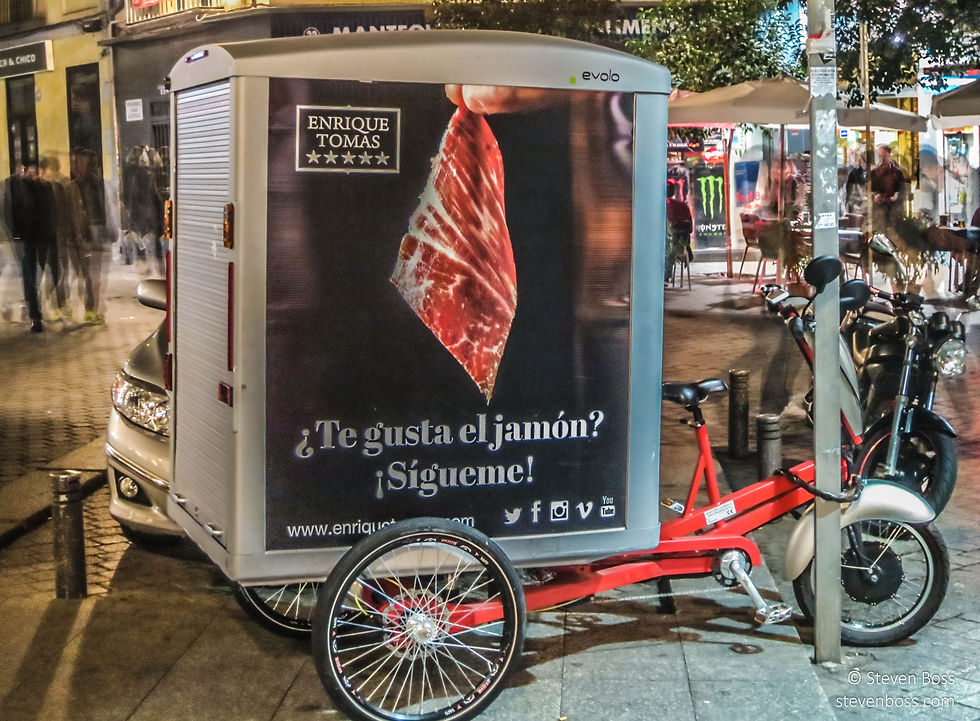 Parked delivery bicycle with ad: "Te gusta el jamón? Sigueme!", Madrid, Spain
