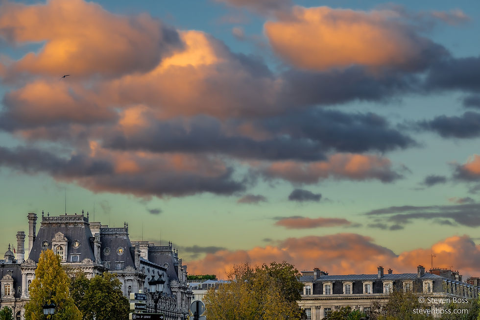 Hôtel de Ville (on the left) - with late setting sun rays on the clouds above, Paris, France