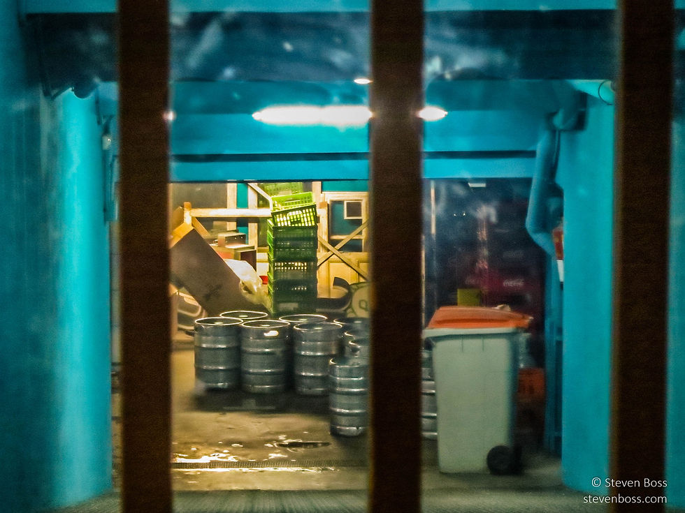 A back garage with steel beer barrels at night, Madrid, Spain