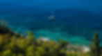 View down the hill to the south to a sailboat in the sea, Taormina, Sicily