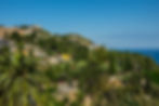 View to the east to the Teatro Antico di Taormina (ancient Greek theater) (on the far left) & to the Villa Comunale - public gardens (center), Taormina, Sicily