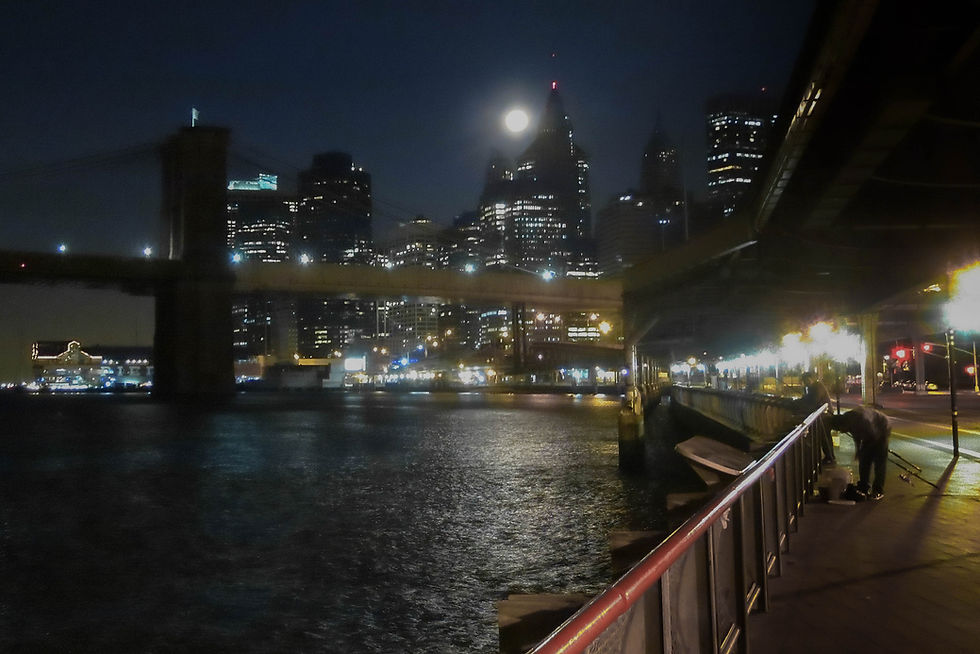 Brooklyn Bridge in early morning darkness with a full moon over lower Manhattan, New York, NY