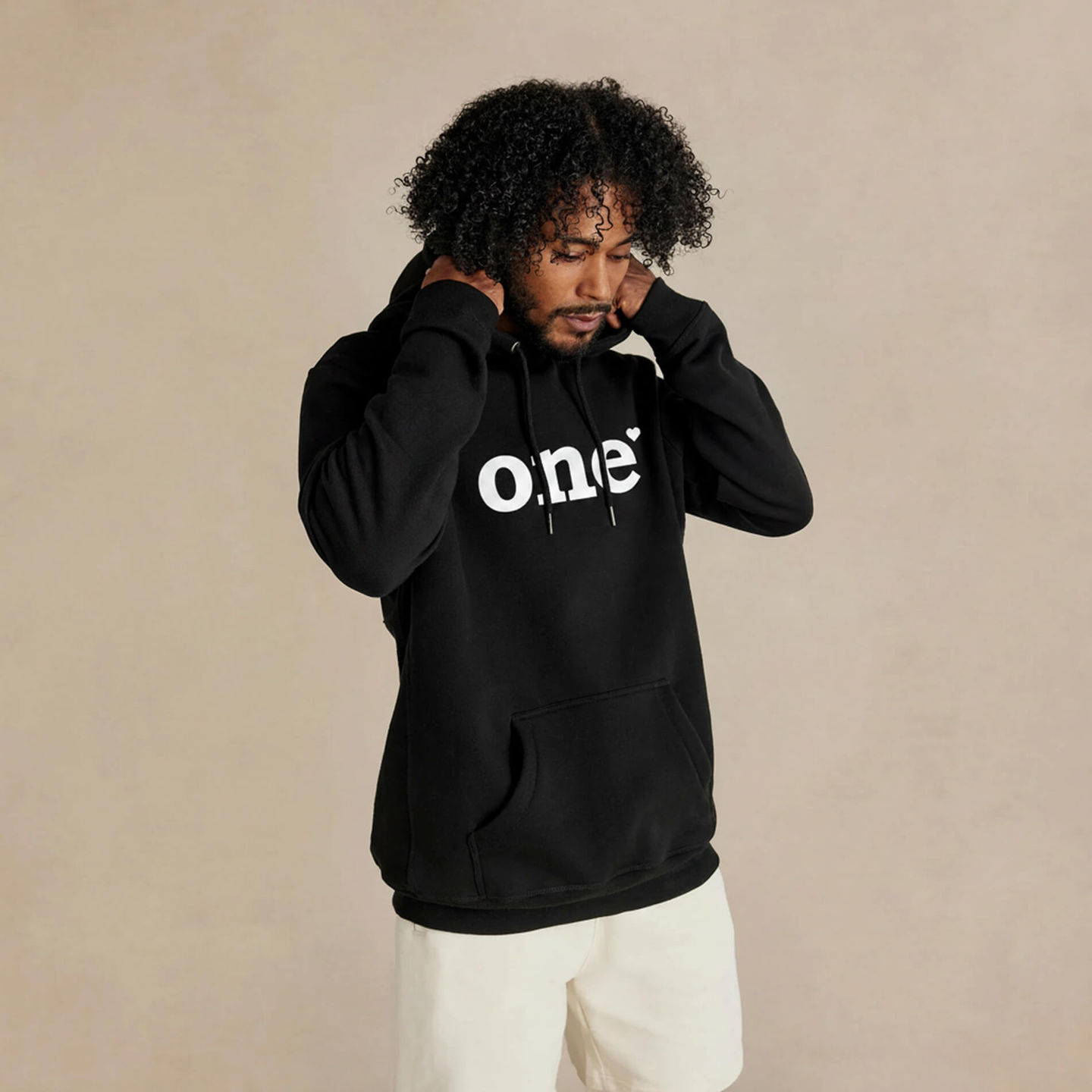 Man wearing the One Love Heavyweight Organic Brushed Unisex Hoodie in black by Kofa Goods