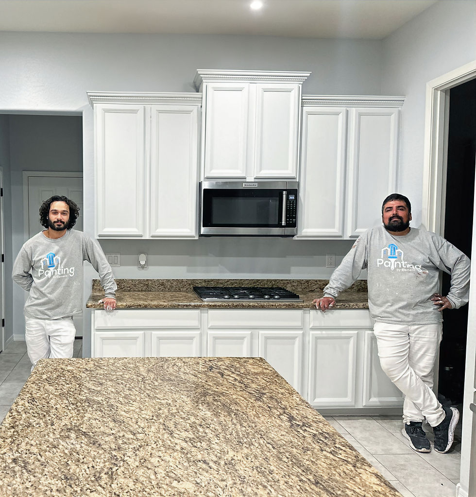 two painting worker employed by painting by element in front of newly painted white interior cabinets