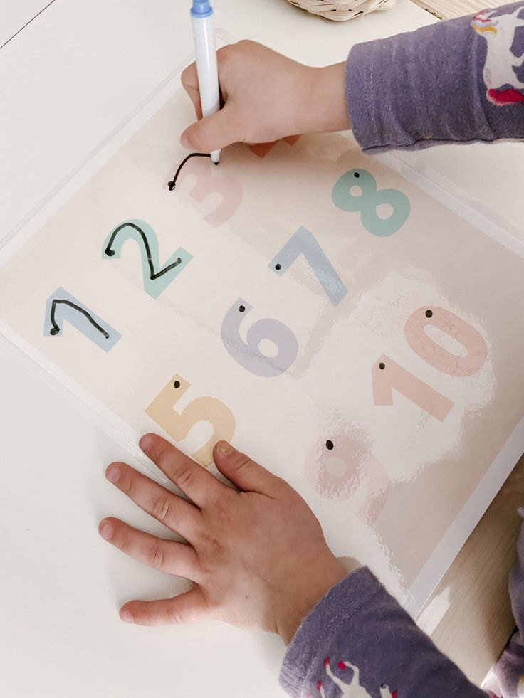 A student at New Discoveries Early Learning Center practicing number recognition and tracing during a structured classroom activity.