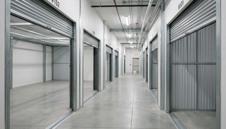 Eye-level view of an empty self-storage hallway with several open units