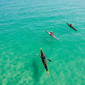 Kayakers gliding across crystal clear water.