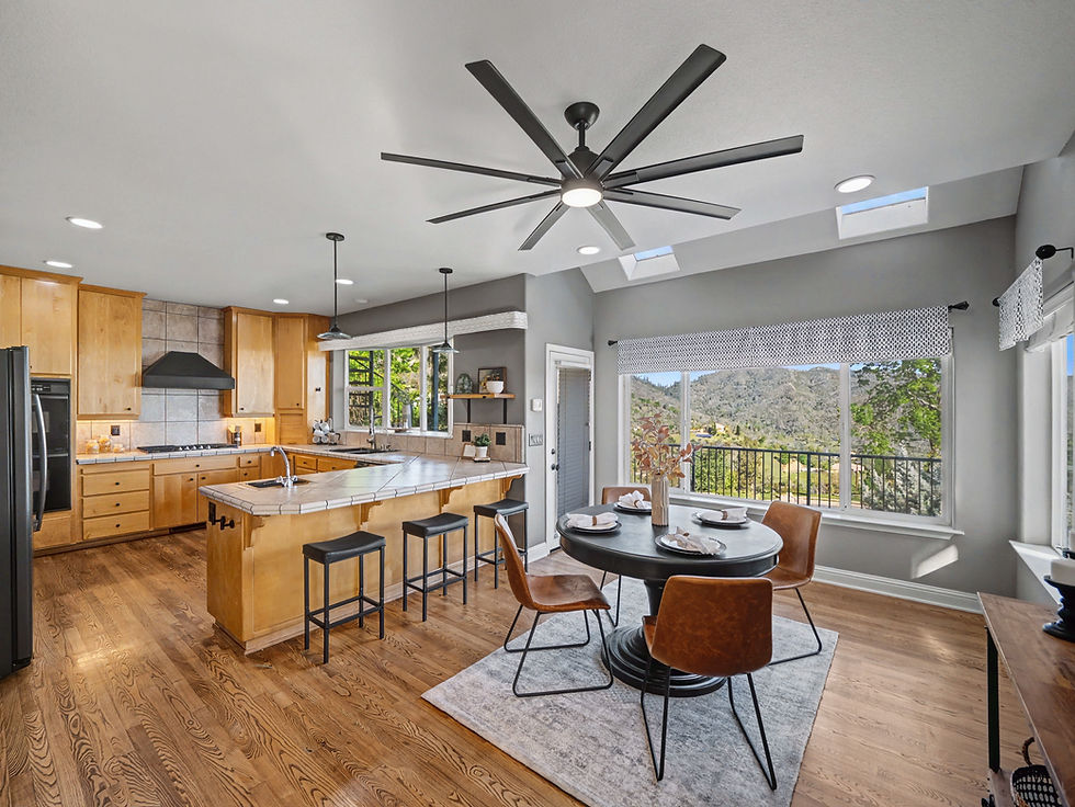 Open kitchen and dining area with hardwood floors and a large picture window in a Redding home.