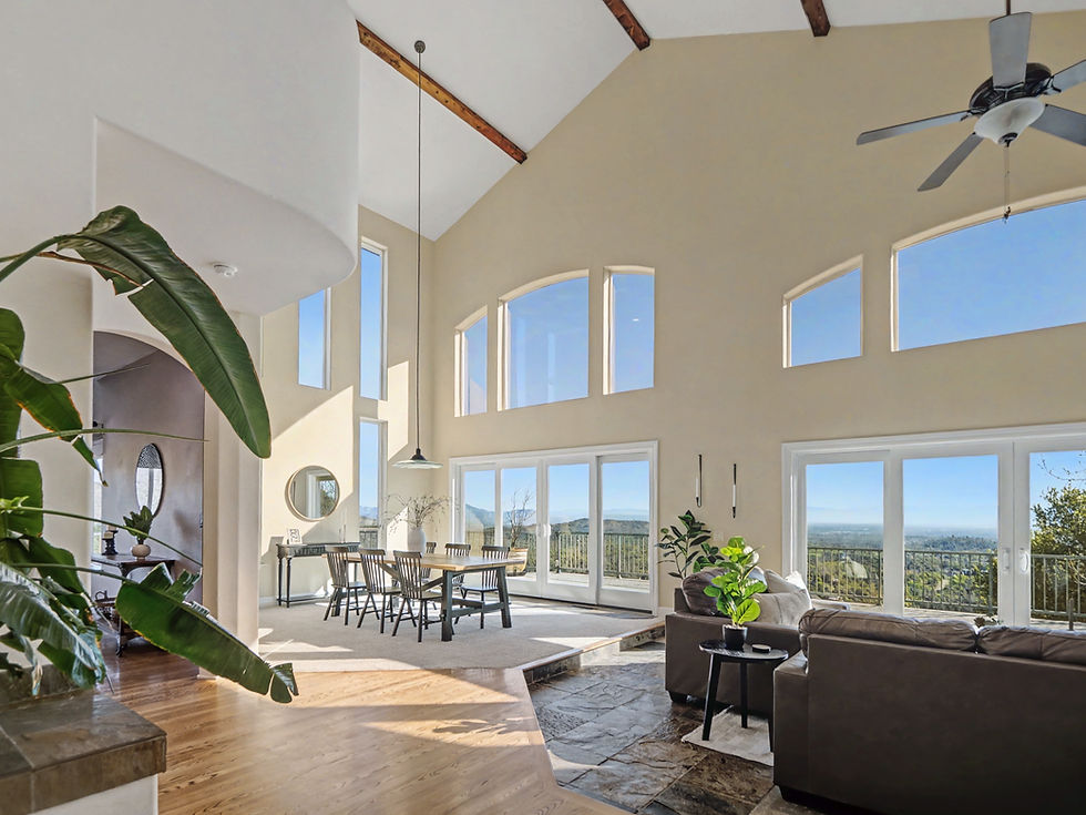 Spacious living room with vaulted ceilings and expansive windows in a Redding, California property.