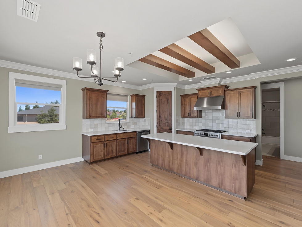 Open kitchen with wood cabinetry, center island and exposed beams photographed for a residential listing.