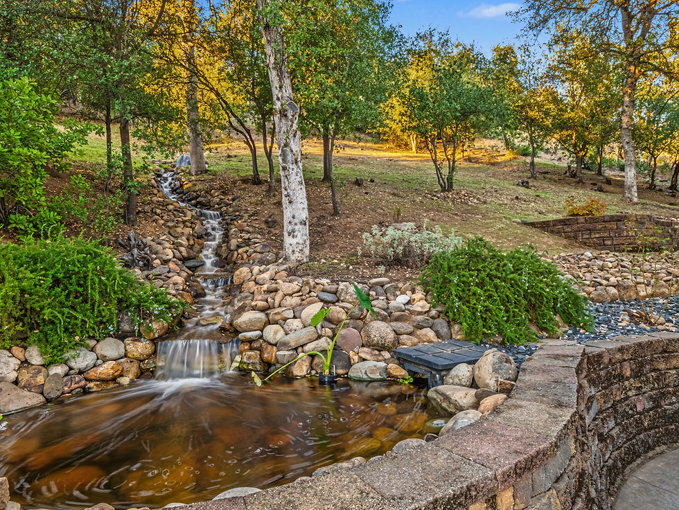 Landscaped creek and rock water feature on a wooded residential property in Shasta County.