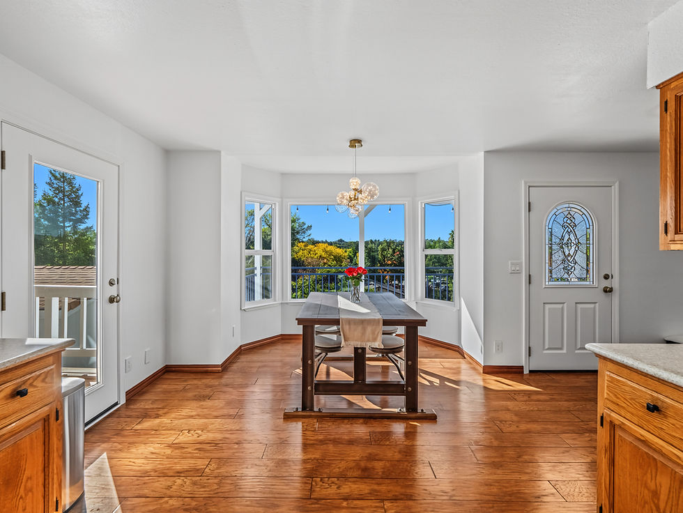 Bright dining area with hardwood floors and multiple windows in a residential home.