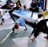 Children practice gymnastics with a gymnastics coach in Fitness in Motion studio