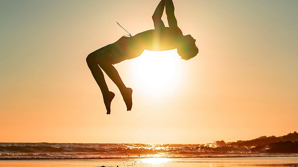 Energetic person jumping on beach at sunset representing vitality and energy benefits of NAD+ IV therapy for cellular rejuvenation and anti-aging wellness
