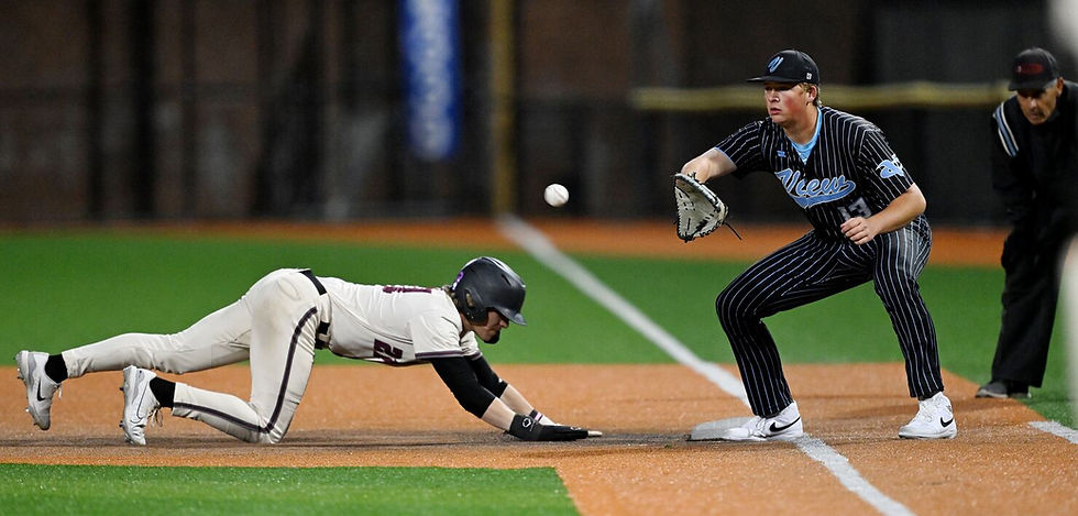 Youth baseball player diving back to first base during a competitive night game, with the first baseman preparing to receive the throw — capturing the explosive athleticism and quick-twitch reactions that make IV hydration therapy essential for young baseball players in Bridgewater and across New Jersey