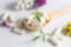 Collagen capsules for skin and beauty in the wooden spoon with herbs and flowers on white ...pt..jpg