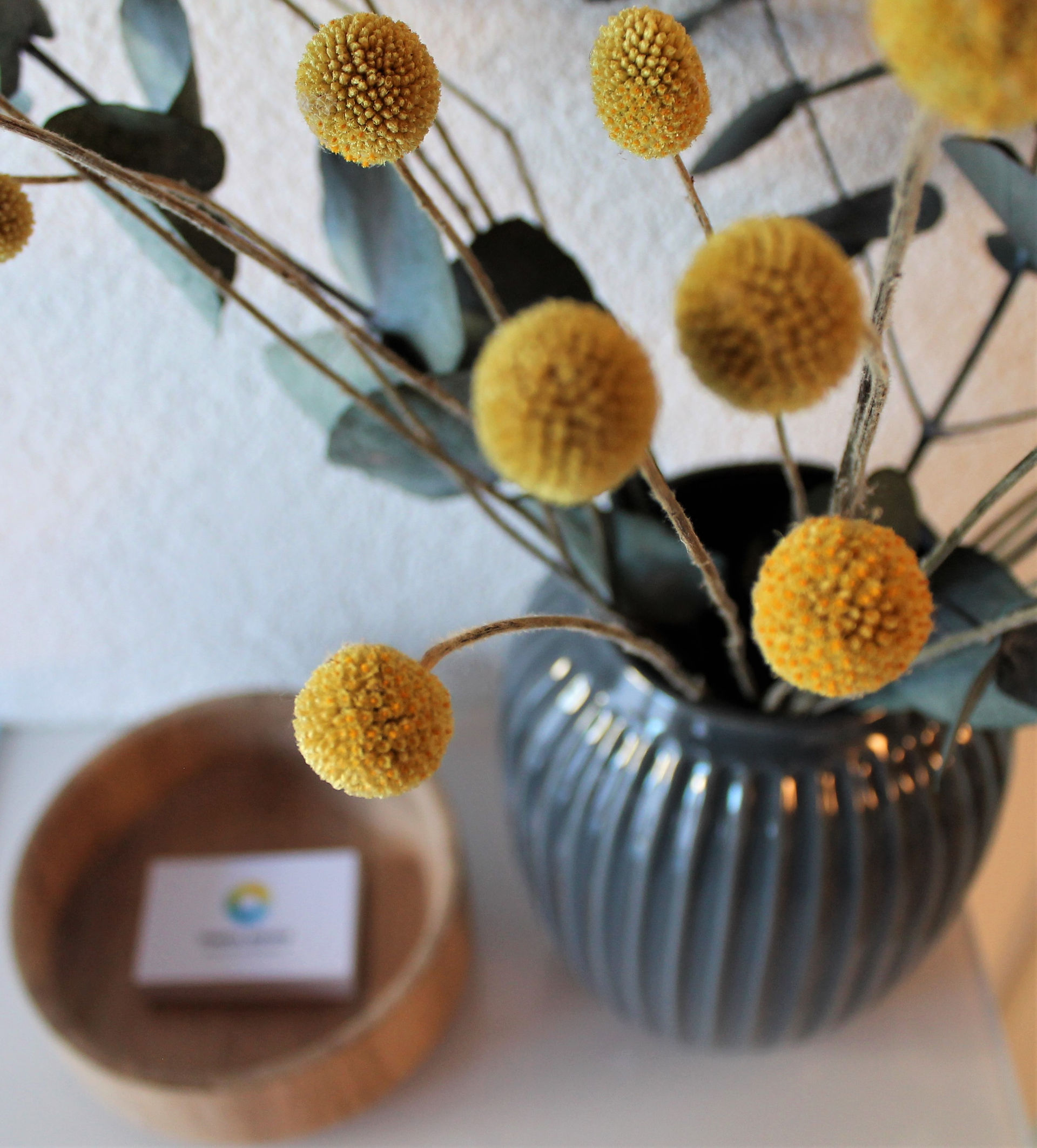 Blumenvase mit Visitenkarten der Praxis im Hintergrund