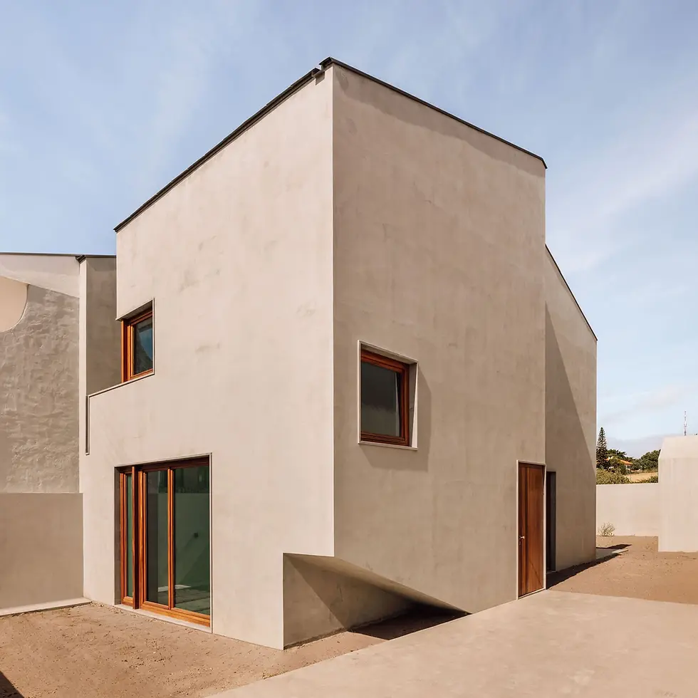 高窄体量与被削切的入口转角共同塑造住宅侧影。
A tall narrow volume and carved entrance corner shape the house profile.
© Francisco Nogueira
