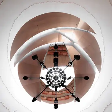 La Source Vive音乐厅室内图片,可开启的铝制声学顶篷围绕圆形天窗展开,让自然光进入排练空间,并参与声音反射控制
La Source Vive concert hall interior: An operable aluminium acoustic canopy opens around the circular oculus, admitting daylight while controll