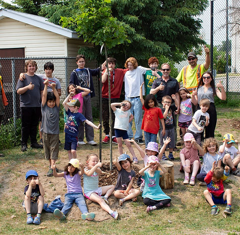 children posing with new tree