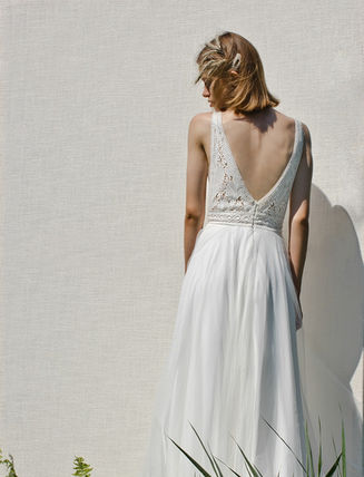 REY verbindet Eleganz und Freiheit: Ein aufwändiges Boho-Spitzenoberteil trifft auf einen fliessenden Chiffonrock. Der tiefe Rückenausschnitt ist der heimliche Star – perfekt für unvergessliche Hochzeitsfotos.