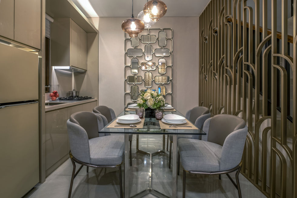 Architectural view of a dining space showcasing a gold geometric metal staircase partition and decorative mirror wall paneling.