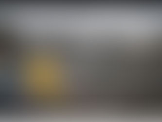 Une petite fille vêtue d'une veste jaune, tenant un seau jaune et une pelle rouge, semble minuscule face à une montagne de déchets plastiques.