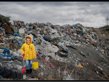 Une petite fille vêtue d'une veste jaune, tenant un seau jaune et une pelle rouge, semble minuscule face à une montagne de déchets plastiques.