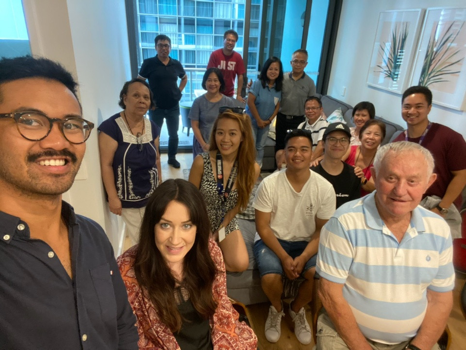 Gail (pictured in the middle with the lanyard) and her family celebrate her new CBD apartment