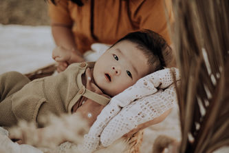 A close-up of baby Enzo, lying on a textured white blanket, gazing softly into the camera. The warm tones and delicate details create a dreamy newborn portrait at Paramount Ranch.