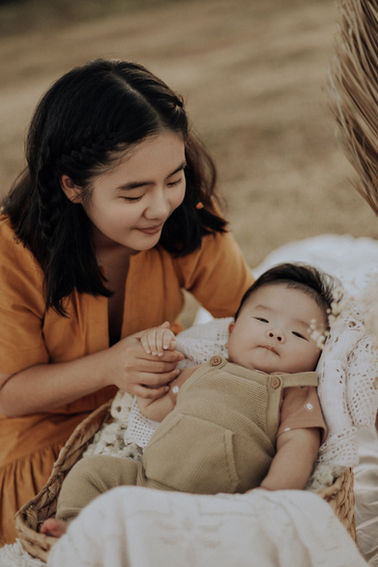 Becky smiles as she gently comforts baby Enzo, who rests peacefully in a soft knit swaddle. The rustic setting of Paramount Ranch adds to the timeless feel of this newborn family session.