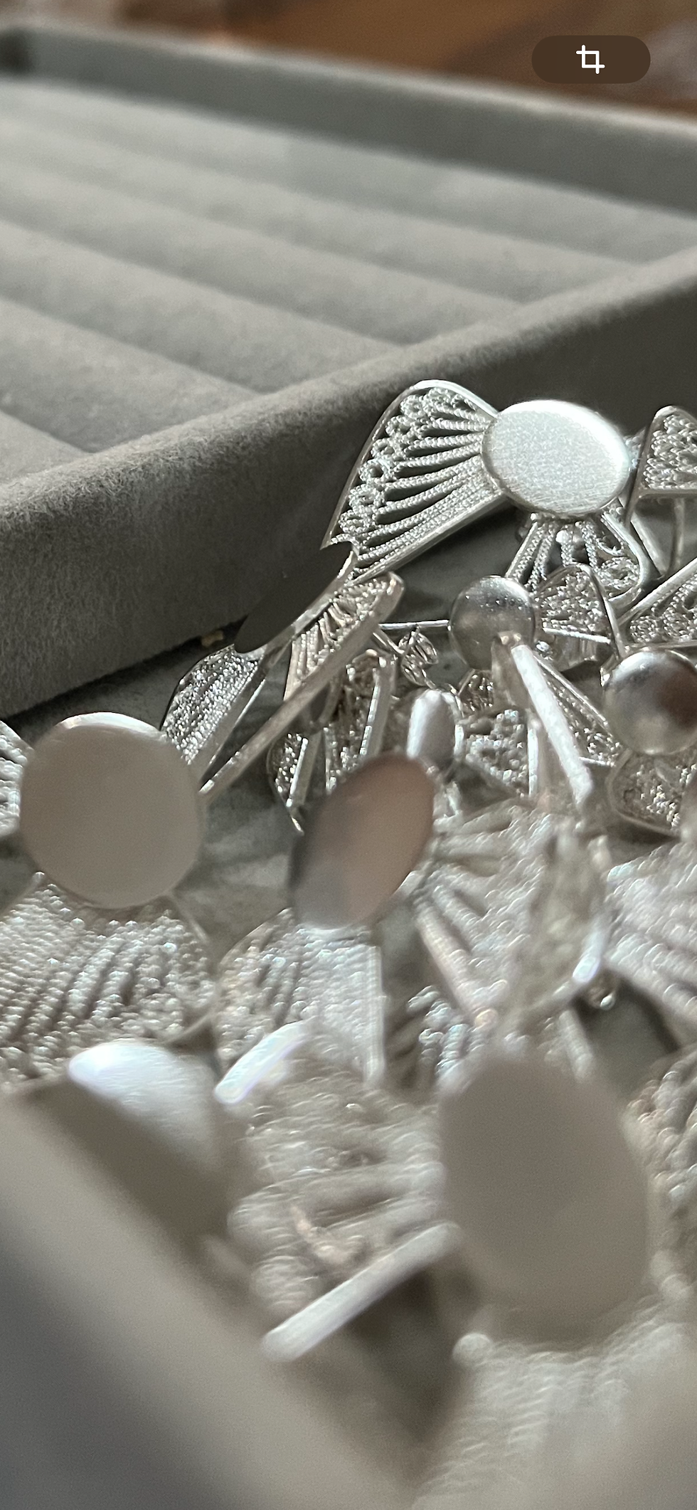 Close-up view of a silver earring being polished by hand