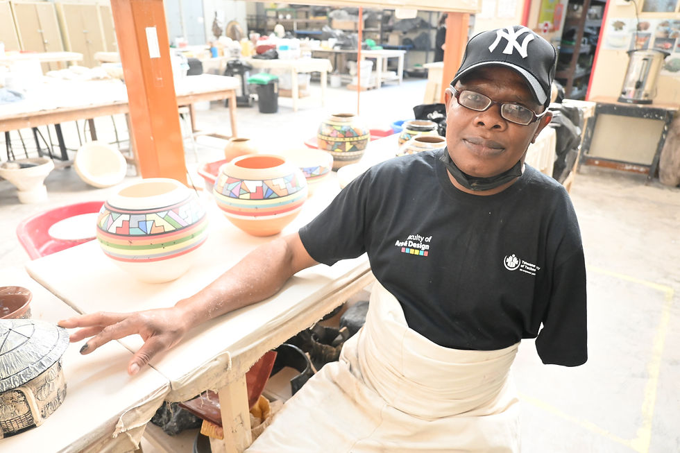 Ceramic artist and TUT lecturer Phineas Makhwiting stands alongside some of his distinctive ceramic creations currently on display at the TUT Arts Festival