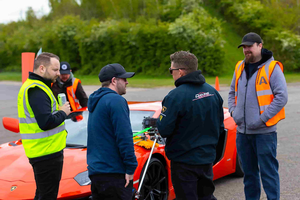 Another World Media crew prepares for a dynamic shoot at Everyman Racing in Leicester, with a vibrant sports car as the backdrop.
