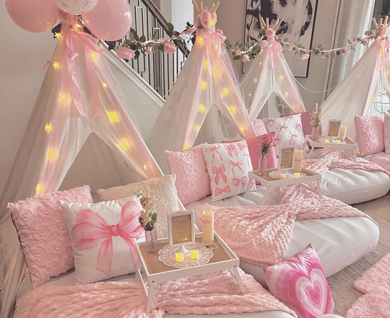 Sleepover teepee party in sarasota florida decorated with shades of pink, bows, and coquette theme. Rental tents are draped with pearls and roses, soft blankets folded in bows, and rugs layer the space to create the best birthday party ever